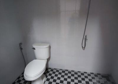 Bathroom with checkered floor tiles and wall-mounted shower