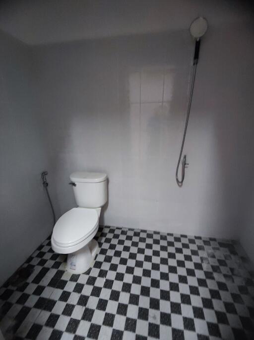 Bathroom with checkered floor tiles and wall-mounted shower