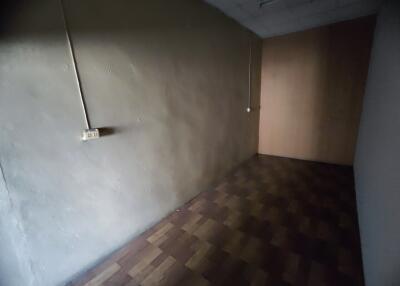 Empty room with wooden floor and electrical outlet