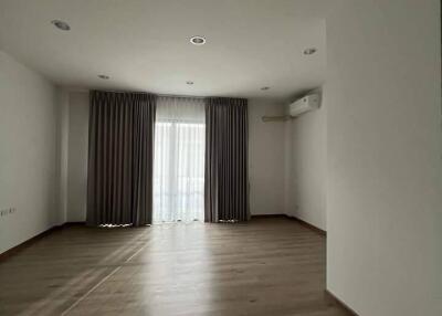 Spacious empty living room with large window and curtains