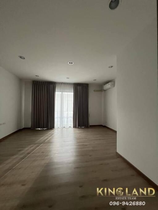 Spacious empty living room with large window and curtains