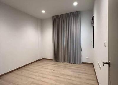 Empty bedroom with wooden floor and curtains