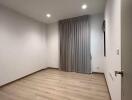 Empty bedroom with wooden floor and curtains