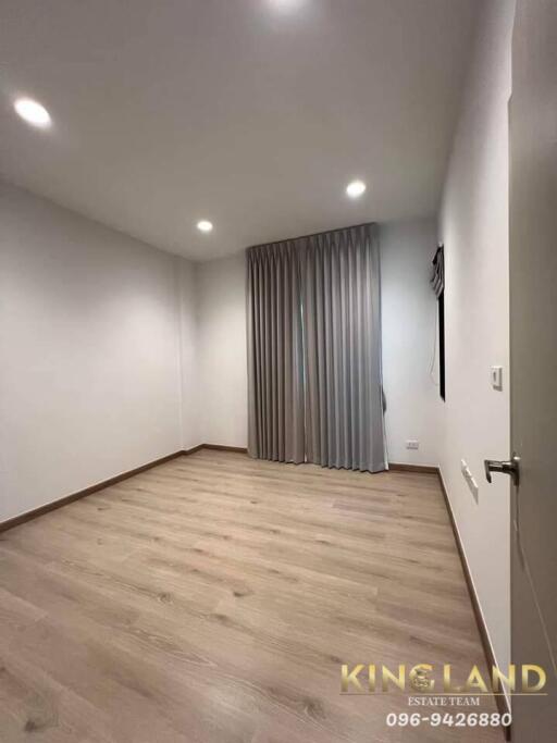 Empty bedroom with wooden floor and curtains