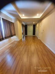 Spacious living room with hardwood floors and large windows