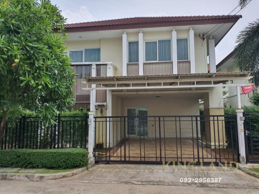 Front view of a two-story house with a gated driveway