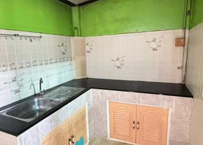 Basic kitchen with green walls and tiled backsplash