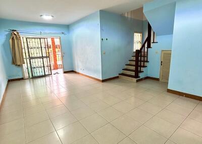 Spacious main living area with tiled floor, blue walls, and staircase