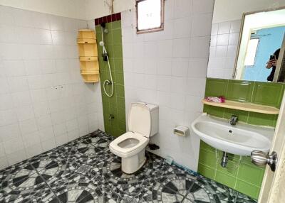 Bathroom with green tiles and geometric-patterned floor