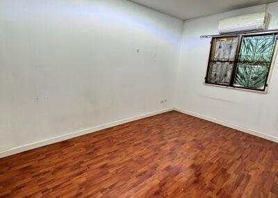 Empty bedroom with wooden floor and window