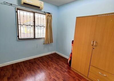 A cozy bedroom with hardwood floors and ample natural light