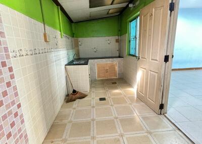 Small kitchen area with green walls and tiled backsplash