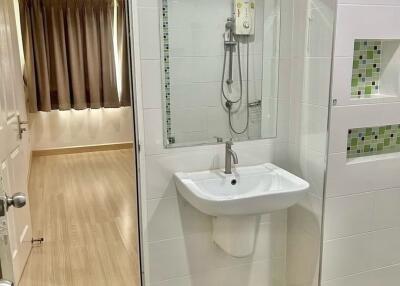 Modern bathroom with wall-mounted sink and shower area