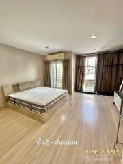 Spacious bedroom with wooden floor, large bed, and balcony access