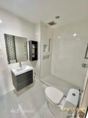 Modern bathroom with sink, mirror, shelves, and toilet