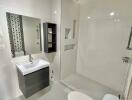 Modern bathroom with sink, mirror, shelves, and toilet