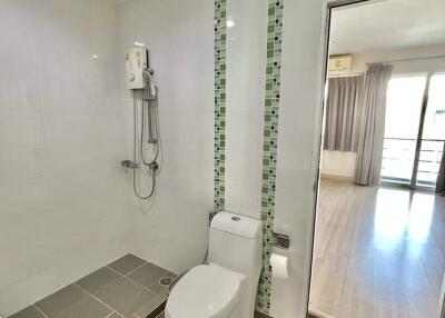 Modern bathroom with shower, toilet, and tile flooring