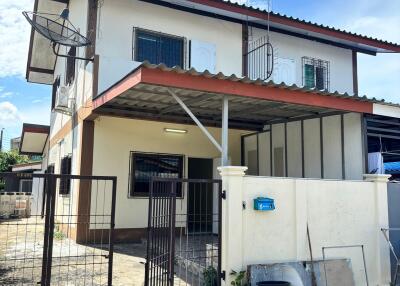 Front view of a two-story residential building with covered carport