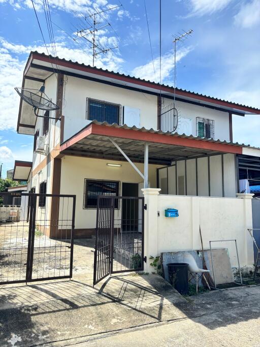 Front view of a two-story residential building with covered carport