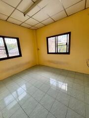 Empty bedroom with tiled floor and large windows