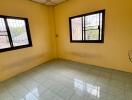 Empty bedroom with tiled floor and large windows