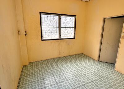 Empty room with tiled floor and barred windows