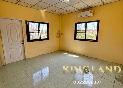 Spacious empty bedroom with tiled flooring and air conditioning