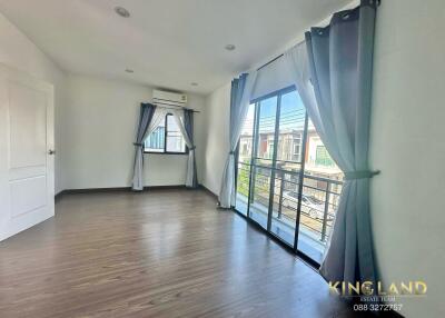 Spacious bedroom with wooden flooring and large windows