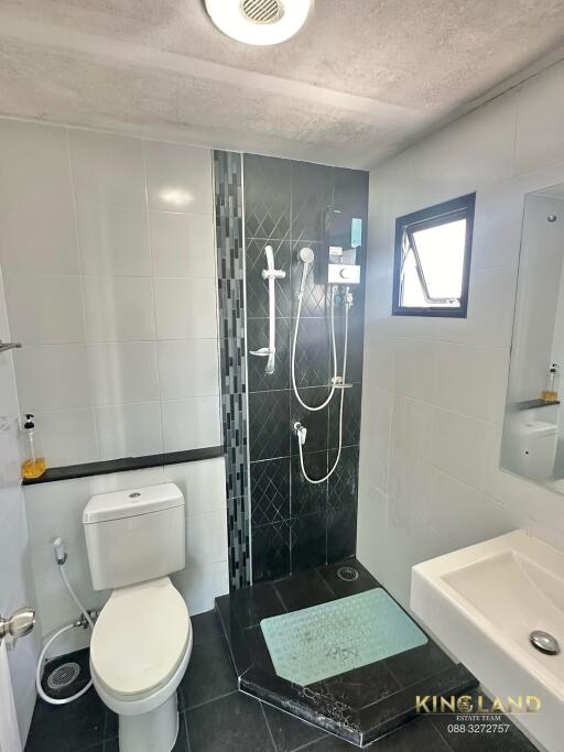 Modern bathroom with toilet, shower, and sink