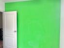 Bedroom with green accent wall and wooden flooring