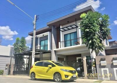 Two-story modern house with yellow car in driveway