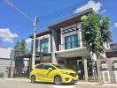 Two-story modern house with yellow car in driveway