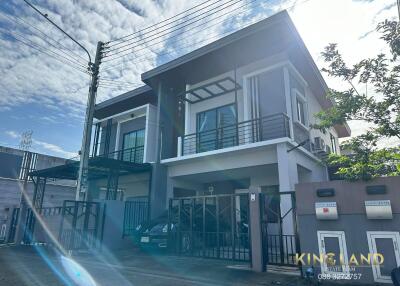 Modern two-story house with large windows and gated driveway