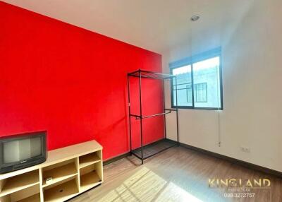 bright bedroom with red accent wall