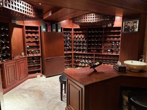 Spacious wine cellar with wooden racks and a refrigerator