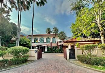 Front view of a large residential property with driveway and garden