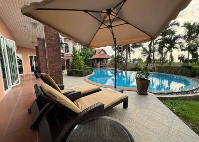 Patio with sun loungers next to a pool