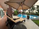 Patio with sun loungers next to a pool