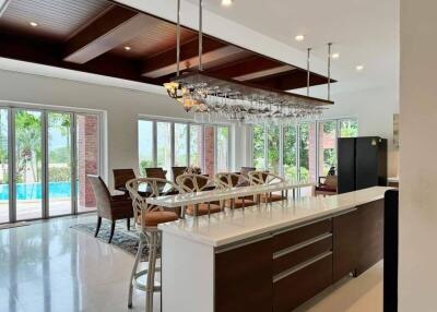 Modern kitchen and dining area with large windows and pool view