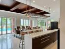 Modern kitchen and dining area with large windows and pool view