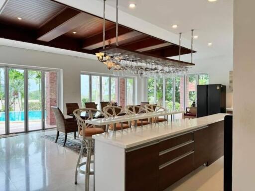 Modern kitchen and dining area with large windows and pool view