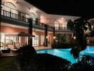 Night view of a large house with a pool and outdoor seating area