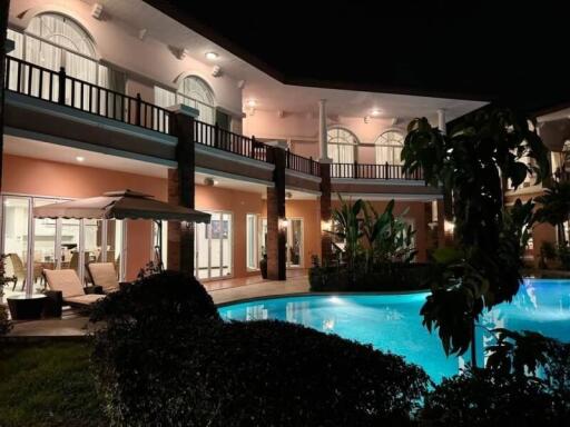 Night view of a large house with a pool and outdoor seating area