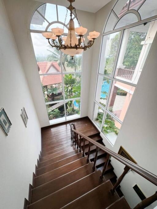 Elegant staircase with large windows and chandelier