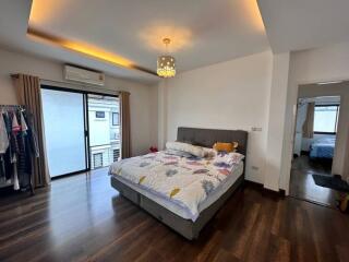 Bedroom with a bed, modern lighting, and a sliding door leading to a balcony