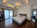 Bedroom with a bed, modern lighting, and a sliding door leading to a balcony