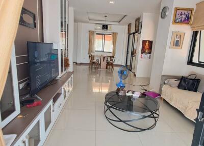 Spacious contemporary living room with TV, coffee table, and serene natural lighting