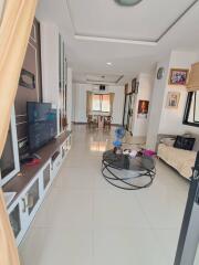 Spacious contemporary living room with TV, coffee table, and serene natural lighting