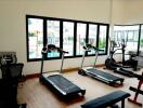 Fitness room with exercise equipment and large windows