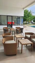 Outdoor seating area with wicker furniture and nearby pool